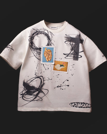 Full front view of the DVYNDRIP Creator T-shirt with abstract artwork, stitched patches, and splatter graphics