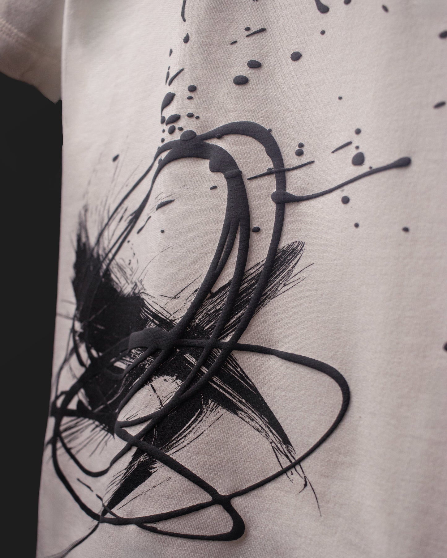Close-up of raised ink and abstract brush print texture on the DVYNDRIP Creator T-shirt