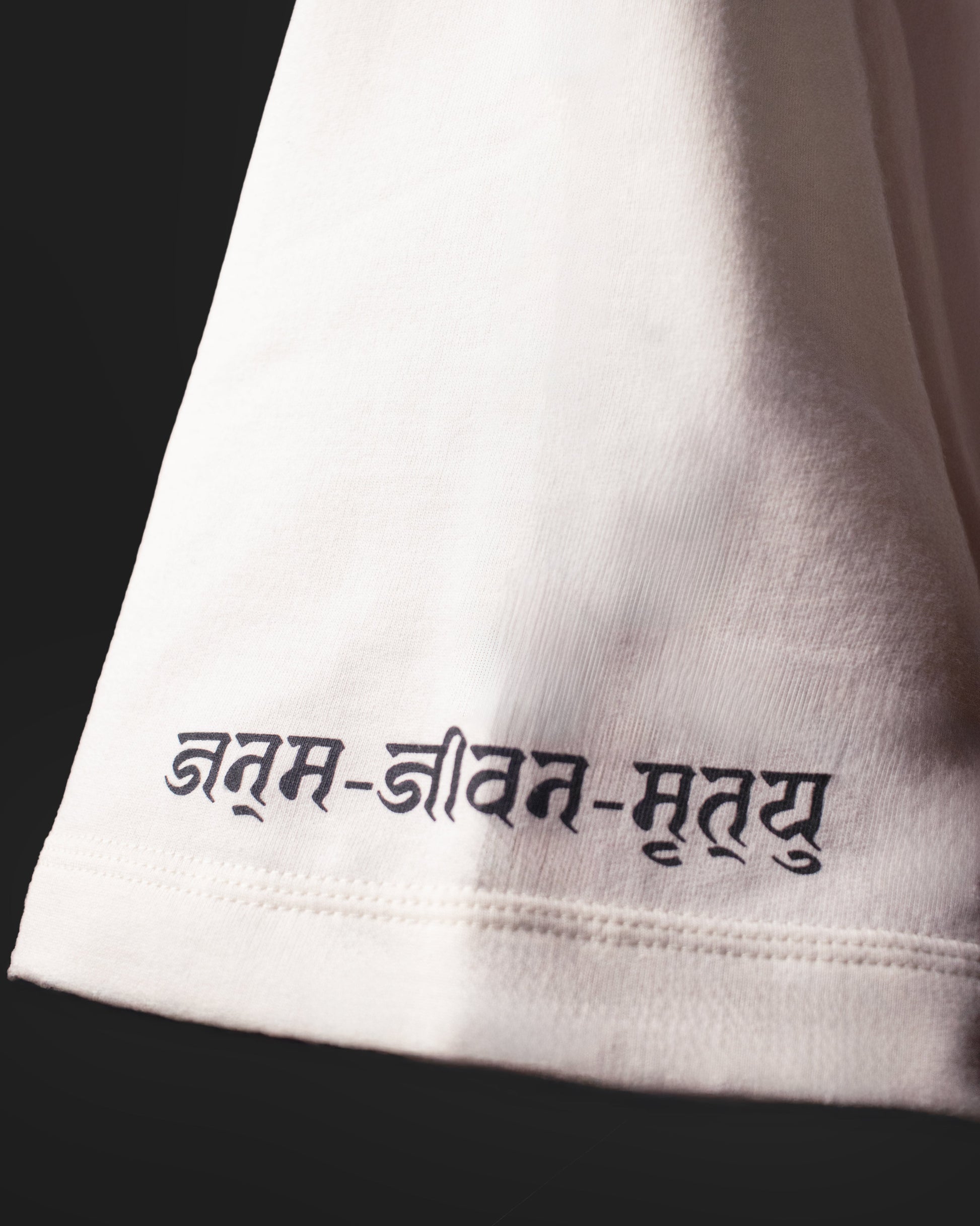 Close-up of Hindi Devnagri text printed on the sleeve of the DVYNDRIP Creator T-shirt