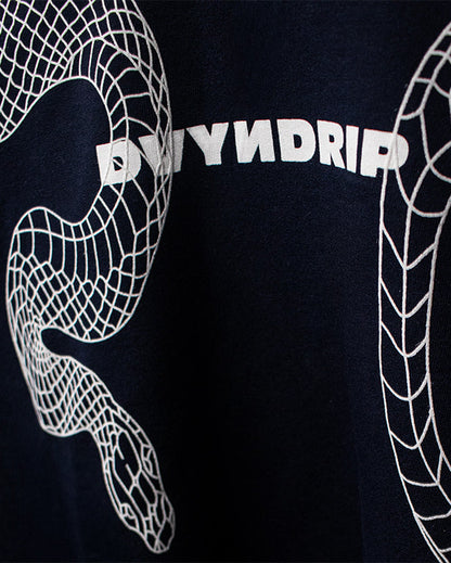 Close-up of the DVYNDRIP Destroyer T-shirt front graphic featuring a white abstract serpent-style line design surrounding the DVYNDRIP logo on navy fabric