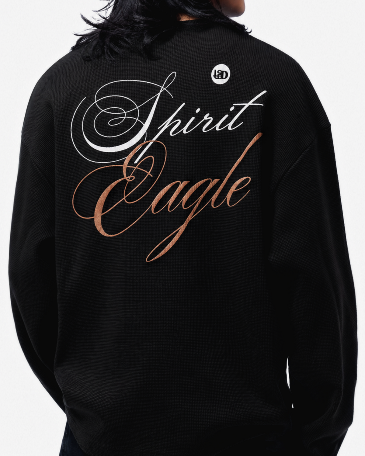 A person viewed from the back wearing a black waffle t-shirt with large decorative text on the back reading 'Spirit Eagle', plus a small circular logo near the upper back.